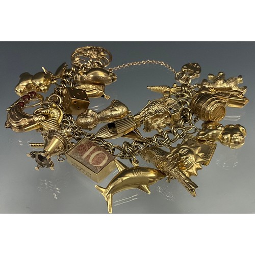 536 - A 9ct gold charm bracelet suspending twenty seven 9ct gold and unmarked yellow metal charms, includi... 