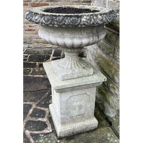 1995 - A pair of Haddonstone type shallow campana shaped half fluted gardens urn on panelled square pedesta... 