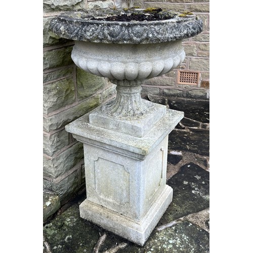 1995 - A pair of Haddonstone type shallow campana shaped half fluted gardens urn on panelled square pedesta... 