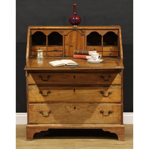 1730 - A George III elm bureau, fall front enclosing a fitted interior, above four long graduated drawers, ... 