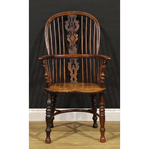 1677 - A 19th century yew and elm Windsor elbow chair, hoop back, unusual splat shaped and pierced with a h... 