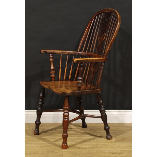 1677 - A 19th century yew and elm Windsor elbow chair, hoop back, unusual splat shaped and pierced with a h... 