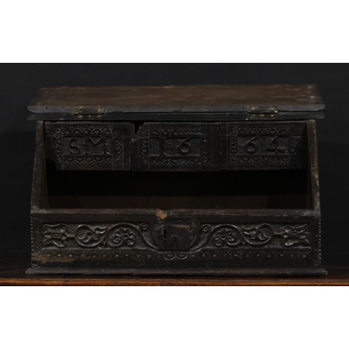 1524 - A 17th century and later oak table box, hinged sloping cover enclosing three small drawers, carved w... 