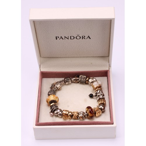 635 - A Pandora charm bracelet, with twenty three 14ct gold, silver and silver gilt charms including angel... 