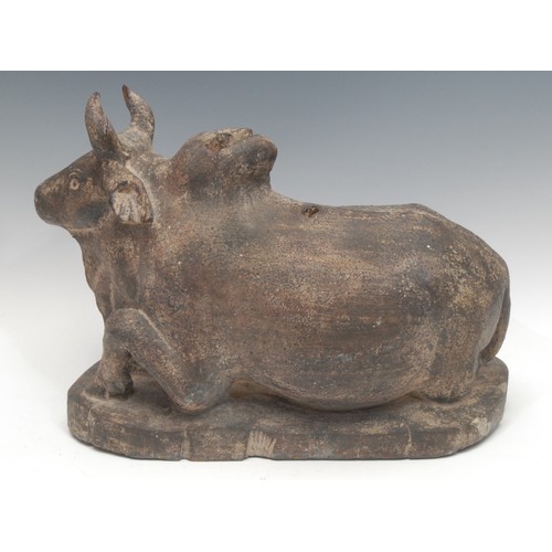 1888 - An Indian softwood carving, of a Nandi bull lodged, in the Hindu manner, 28cm high, 38cm long