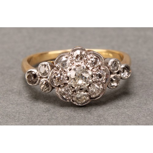 527 - A 19th century diamond ring, central nine stone daisy head between three stone set shoulders, total ... 