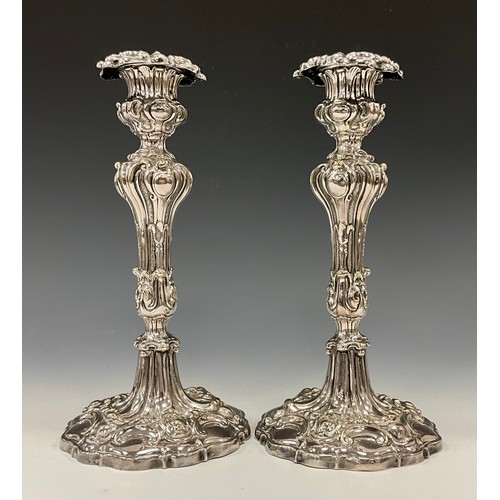 40 - A pair of Victorian Rococo Revival Sheffield silver plated candlesticks, weighted bases, 25.5cm high... 