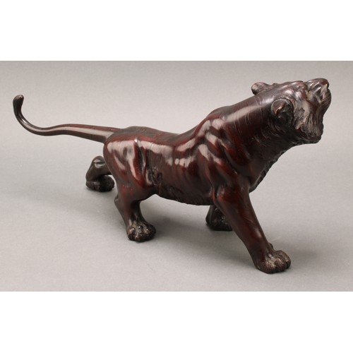 1401 - Japanese School (Meiji period), a pair of two-tone brown patinated bronzes, of tigers, prowling, sig... 