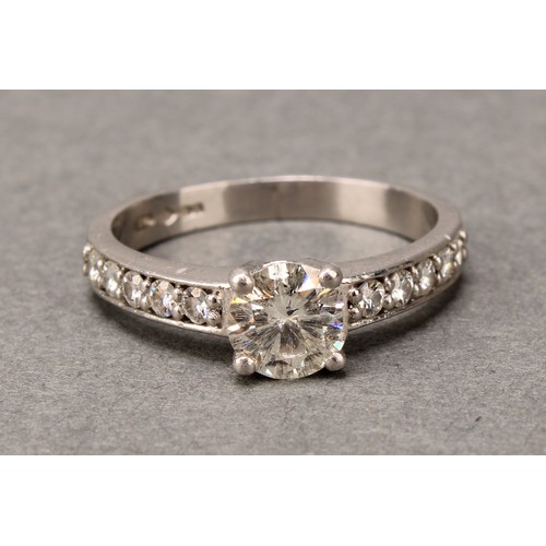 575 - A diamond ring, claw set brilliant cut stone flanked by two rows of five further stones, platinum sh... 