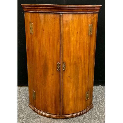 1735 - A George III mahogany bow-front corner cupboard, 113cm high, 75.5cm wide, 50.5cm deep, c.1800