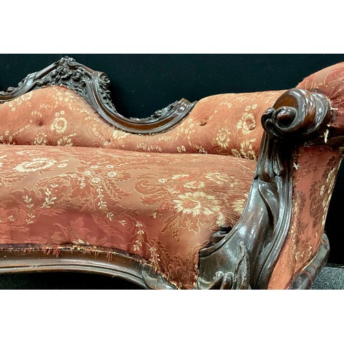 1618 - A Victorian carved walnut chaise longue, spoon-back, with Rococo style scroll arms, carved floral fr... 