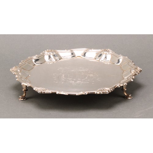 268 - A George II silver shaped circular salver, fluted shell and scroll border, armorial field, hoof feet... 