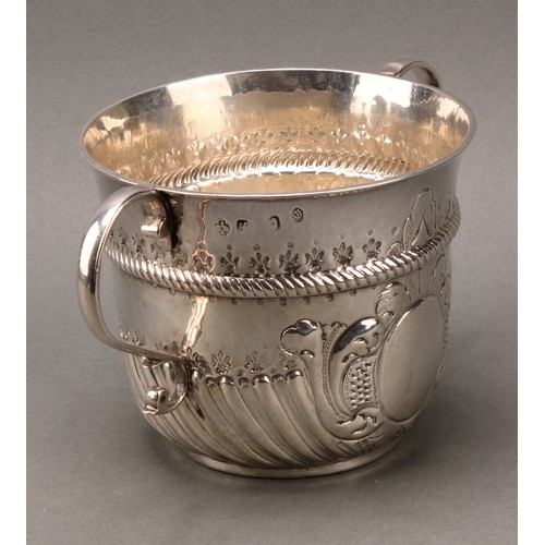 367 - A large Queen Anne silver porringer, wrythen-fluted below a chased rope-twist girdle, scroll handles... 