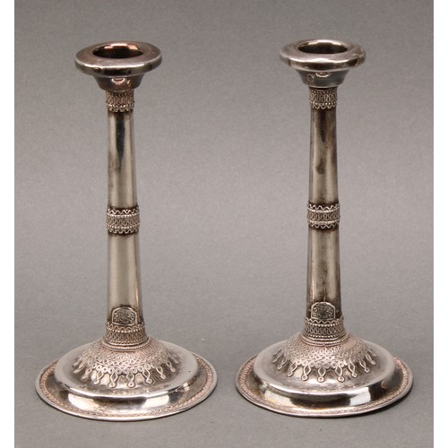 184 - Judaica - a pair of early 20th century Jewish silver candlesticks, typically applied with filigree s... 