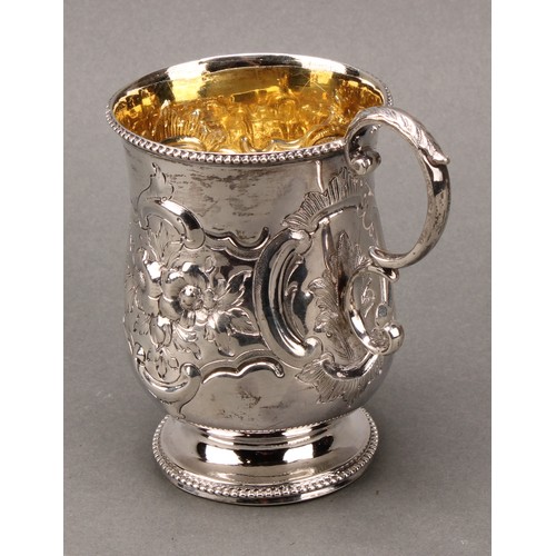 277 - A Victorian silver pedestal mug, chased with scrolls, flowers and foliage, acanthus-capped double sc... 