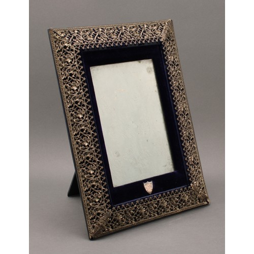 31 - A large Victorian E.P.N.S mounted easel photograph frame, the pierced border embossed with scrolling... 