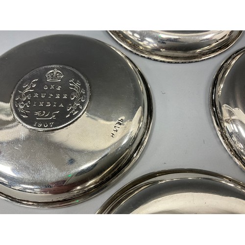 399 - A set of four silver Indian coin pin dishes, each marked one Rupee, dates, 1878, 1888, 1907, 1919, 8... 