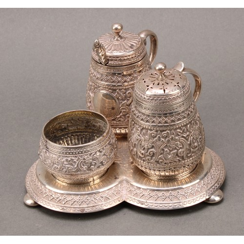 320 - A Victorian silver trefoil cruet, chased in the Indian taste with flowers and dense scrolling foliag... 