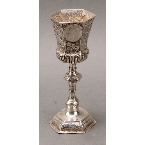 94 - A German silver pedestal cup, hexagonal bell shaped bowl set with coins, knopped stem, domed foot ch... 