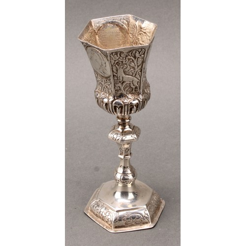 94 - A German silver pedestal cup, hexagonal bell shaped bowl set with coins, knopped stem, domed foot ch... 