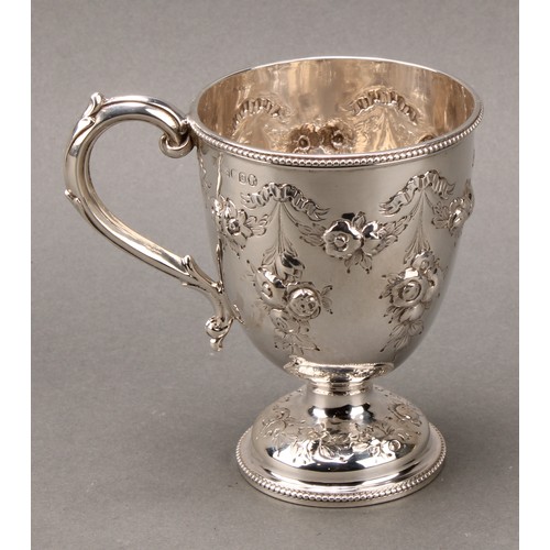 276 - A Victorian silver pedestal mug, chased with ribbon-tied flowering swags and pendants, beaded border... 