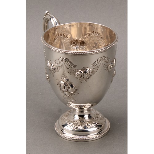 276 - A Victorian silver pedestal mug, chased with ribbon-tied flowering swags and pendants, beaded border... 