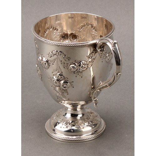 276 - A Victorian silver pedestal mug, chased with ribbon-tied flowering swags and pendants, beaded border... 