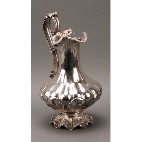 437 - A William IV Rococo Revival silver fluted pedestal wine ewer, hinged cover with flower finial, acant... 