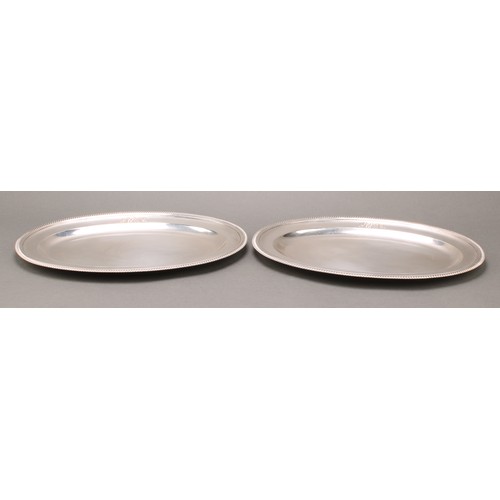 297 - Paul Storr - a pair of George III silver oval meat plates, gadrooned borders, 33cm wide, London 1802... 