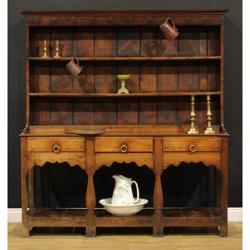 1898 - A George III oak pot board dresser, probably Welsh, the superstructure with two plate rack shelves a... 