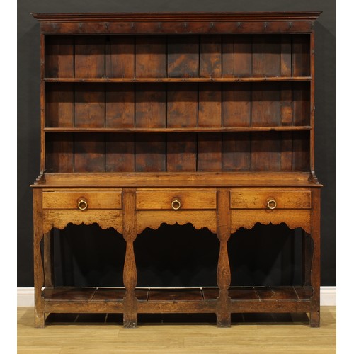 1898 - A George III oak pot board dresser, probably Welsh, the superstructure with two plate rack shelves a... 