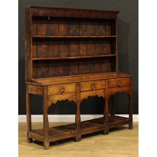 1898 - A George III oak pot board dresser, probably Welsh, the superstructure with two plate rack shelves a... 