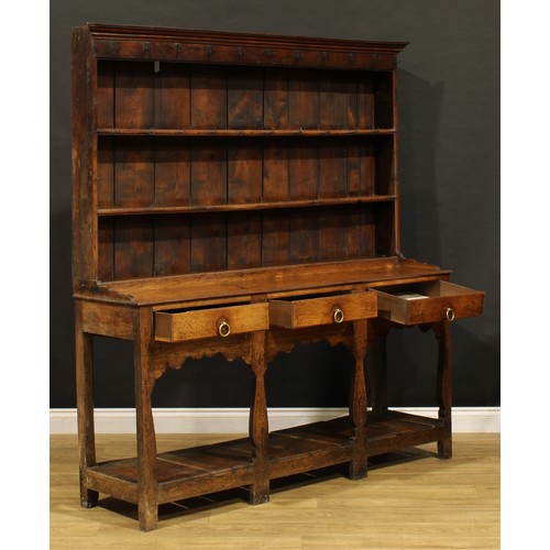 1898 - A George III oak pot board dresser, probably Welsh, the superstructure with two plate rack shelves a... 