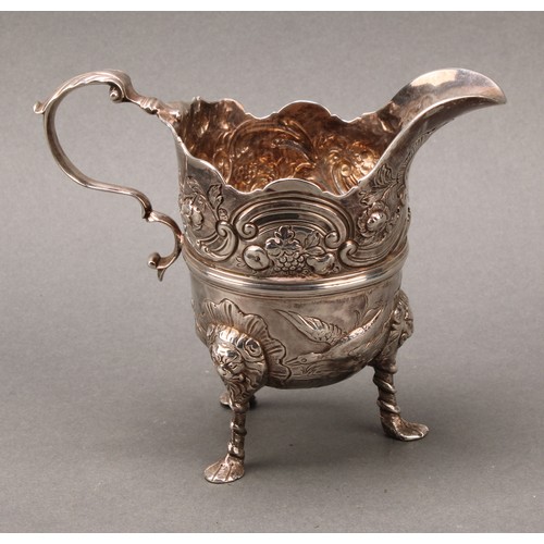 445 - An 18th century Irish silver cream jug, of bold design, chased with ducks taking to flight, flowers,... 