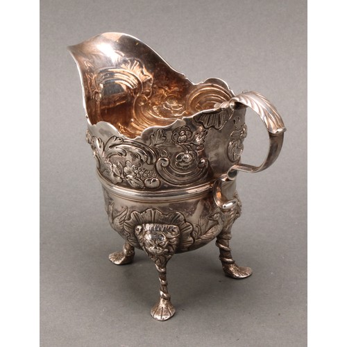 445 - An 18th century Irish silver cream jug, of bold design, chased with ducks taking to flight, flowers,... 