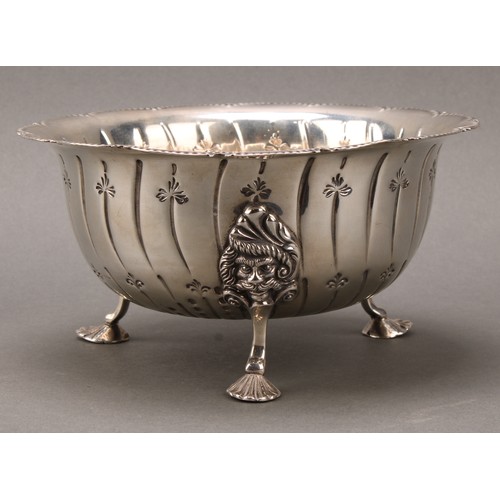 286 - An Irish silver shaped circular bowl, spirally fluted, scroll legs with masks to knees, shell feet, ... 