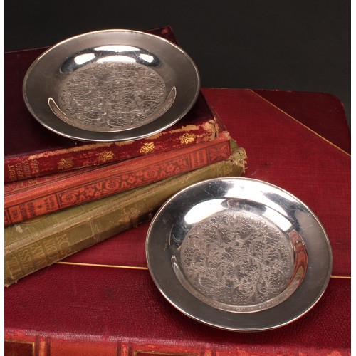 371 - A pair of Chinese silver circular dishes, chased with a field of fruiting vine, 11.5cm diam, Wang Hi... 