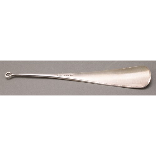 291 - Asprey - a George V silver shoe horn, engine turned, button hook terminal, 23cm long, London 1929, 9... 