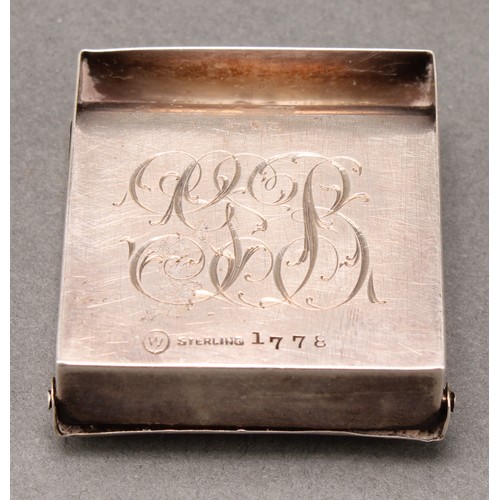 457 - An early 20th century American silver stamp box, hinged cover embossed with a putto amongst flowers,... 