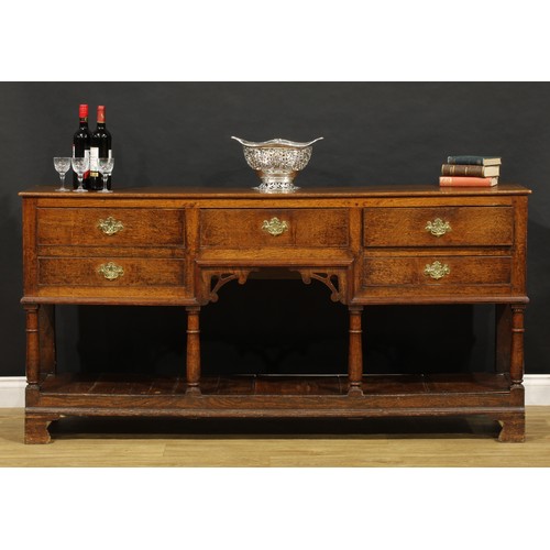 1543 - A George III and later oak low pot board dresser, slightly oversailing top above an arrangement of f... 