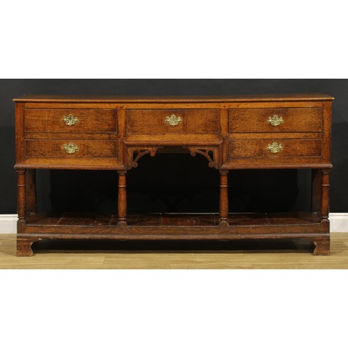 1543 - A George III and later oak low pot board dresser, slightly oversailing top above an arrangement of f... 