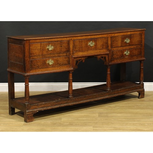 1543 - A George III and later oak low pot board dresser, slightly oversailing top above an arrangement of f... 