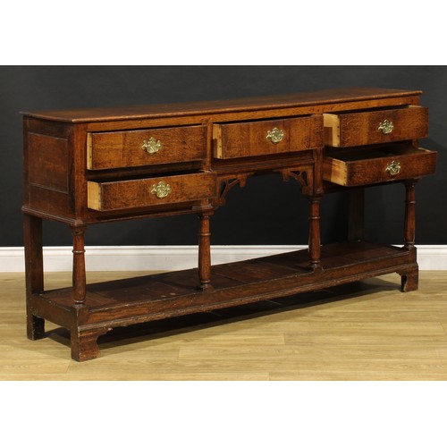 1543 - A George III and later oak low pot board dresser, slightly oversailing top above an arrangement of f... 