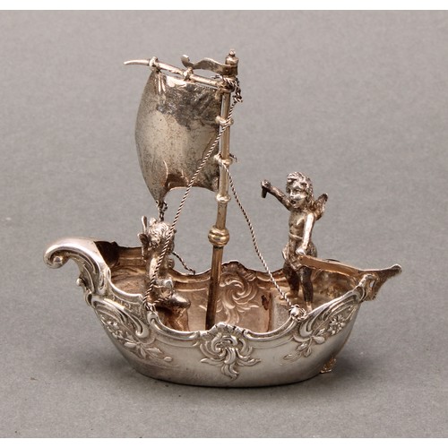 230 - Silver Toys and Miniatures - a Continental silver coloured metal novelty model, of putti sailing a s... 