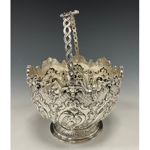 285 - A Victorian silver swing handled sugar bowl, deeply embossed with acanthus, scrolls and scaled motif... 