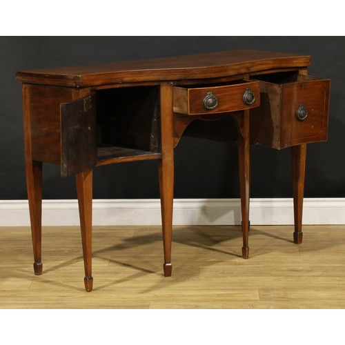 1685 - A George III Revival mahogany serpentine serving table, oversailing top outlined with barber pole st... 