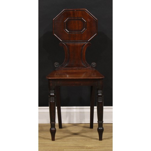 1610 - A pair of George/William IV mahogany hall chairs, each shaped back with octagonal cresting above C-s... 