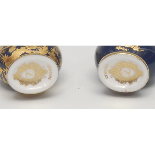 1224 - A pair of Lynton porcelain baluster scent bottles, decorated in gilt with birds amongst foliage, des... 