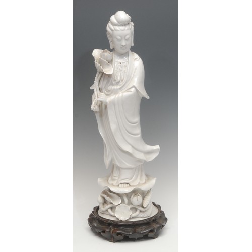 1208 - A large Republic period Chinese blanc de chine porcelain figure, of Guanyin, she stands holding a lo... 