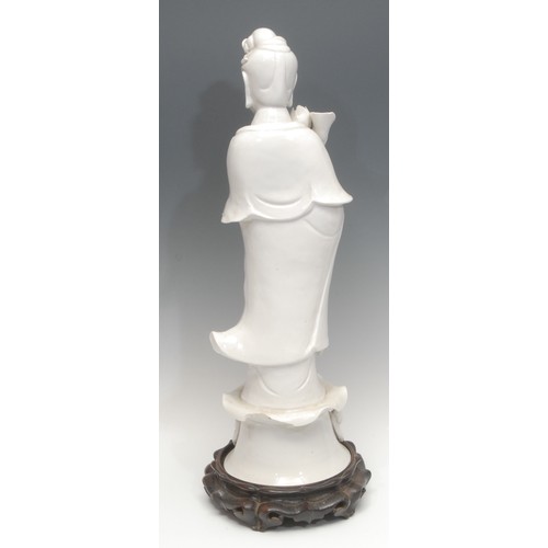 1208 - A large Republic period Chinese blanc de chine porcelain figure, of Guanyin, she stands holding a lo... 